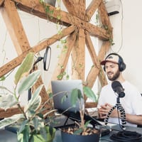 a man in white shirt doing audio podcast