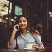 portrait of young woman using mobile phone in cafe