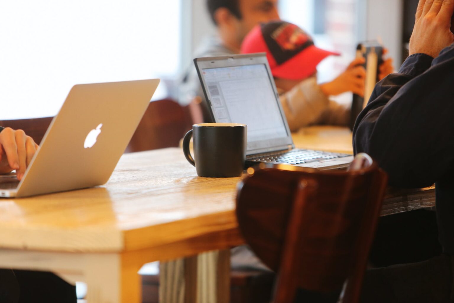 people using laptops while sitting on chair